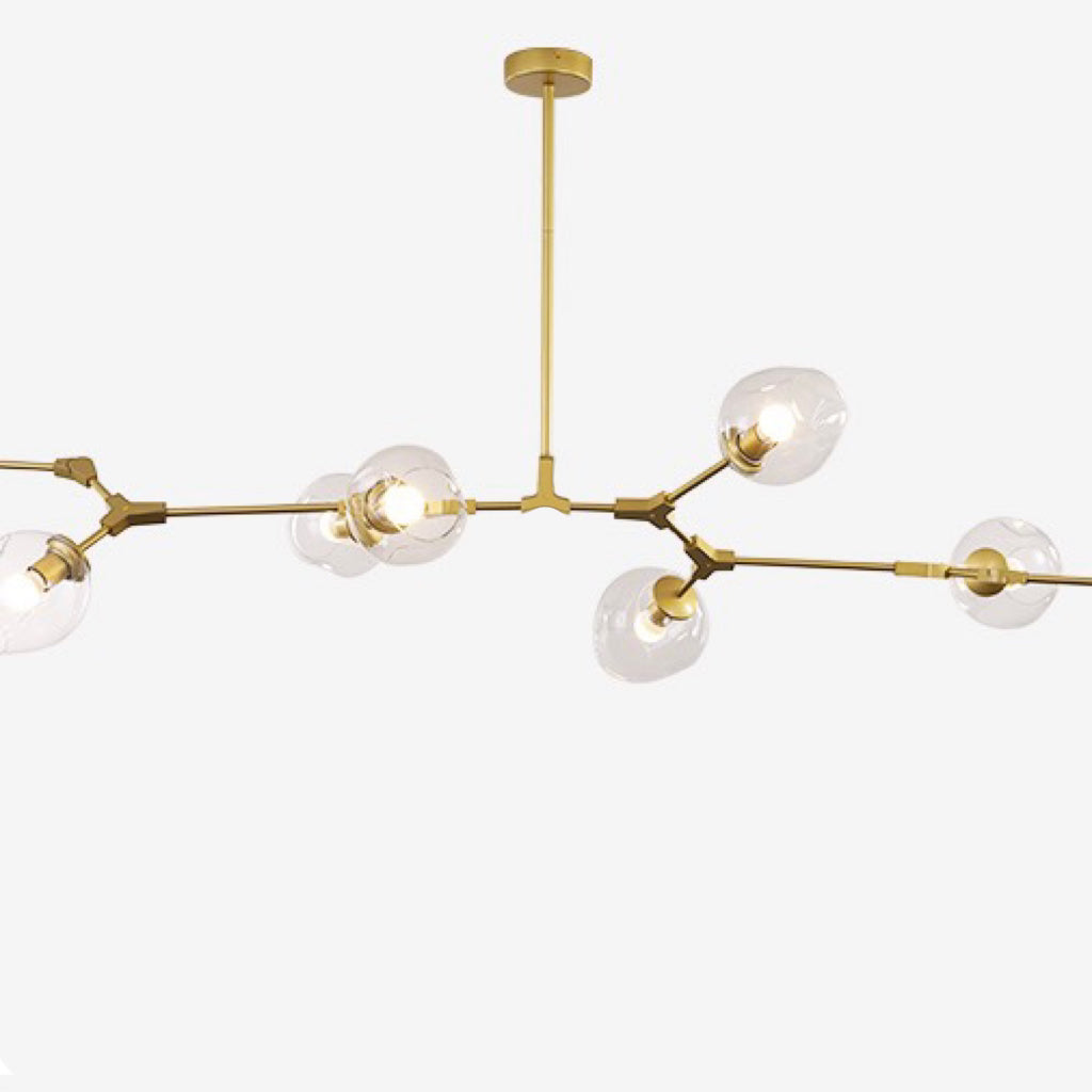Cropped studio view of the gold Clérachic arms, clear dimpled globes screwed to brass sockets along the branching stem.