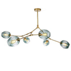 Gold-armed Clérachic chandelier with gradient gray-green globes lit by filament bulbs, shown against a plain studio white.