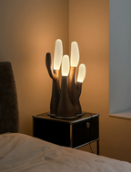 This Clérachic table lamp in light wood glows atop a black nightstand in a warm-lit bedroom corner.