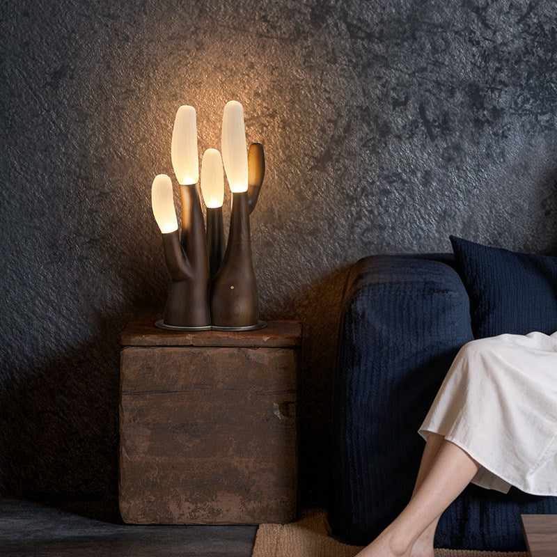 This dark-wood Clérachic table lamp glows on a rustic crate beside a navy cushion and bare feet.