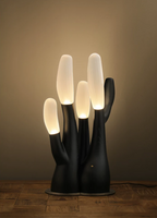 Warm ambient light surrounds this black Clérachic table lamp, its branch tips glowing softly.