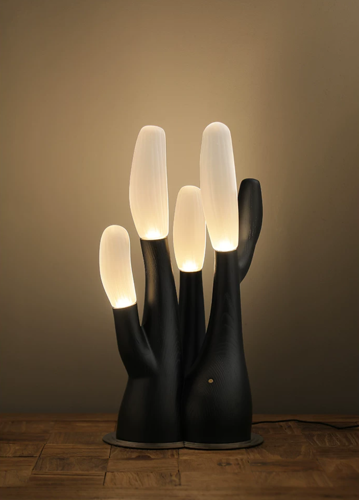 Warm ambient light surrounds this black Clérachic table lamp, its branch tips glowing softly.