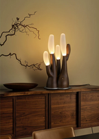 This dark-wood Clérachic table lamp glows on a walnut sideboard beside a bowl and bare branches.