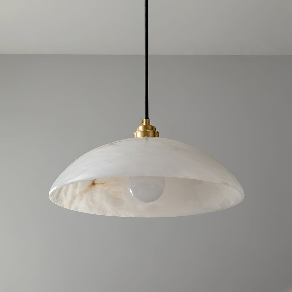Clérachic pendant with a veined alabaster dome, a brass cap and a frosted bulb, photographed against a plain grey wall.