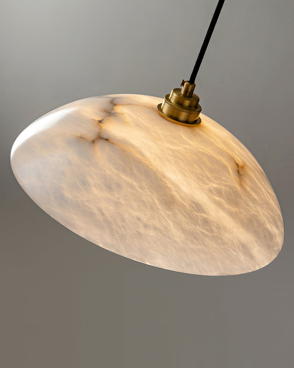 Tilted view into the underside of this Clérachic alabaster dome, glowing with soft brown veining around a brass lamp holder.