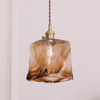 Close view of the squared amber glass shade on this Clérachic pendant, with swirled brown streaks and a thick fused hem.