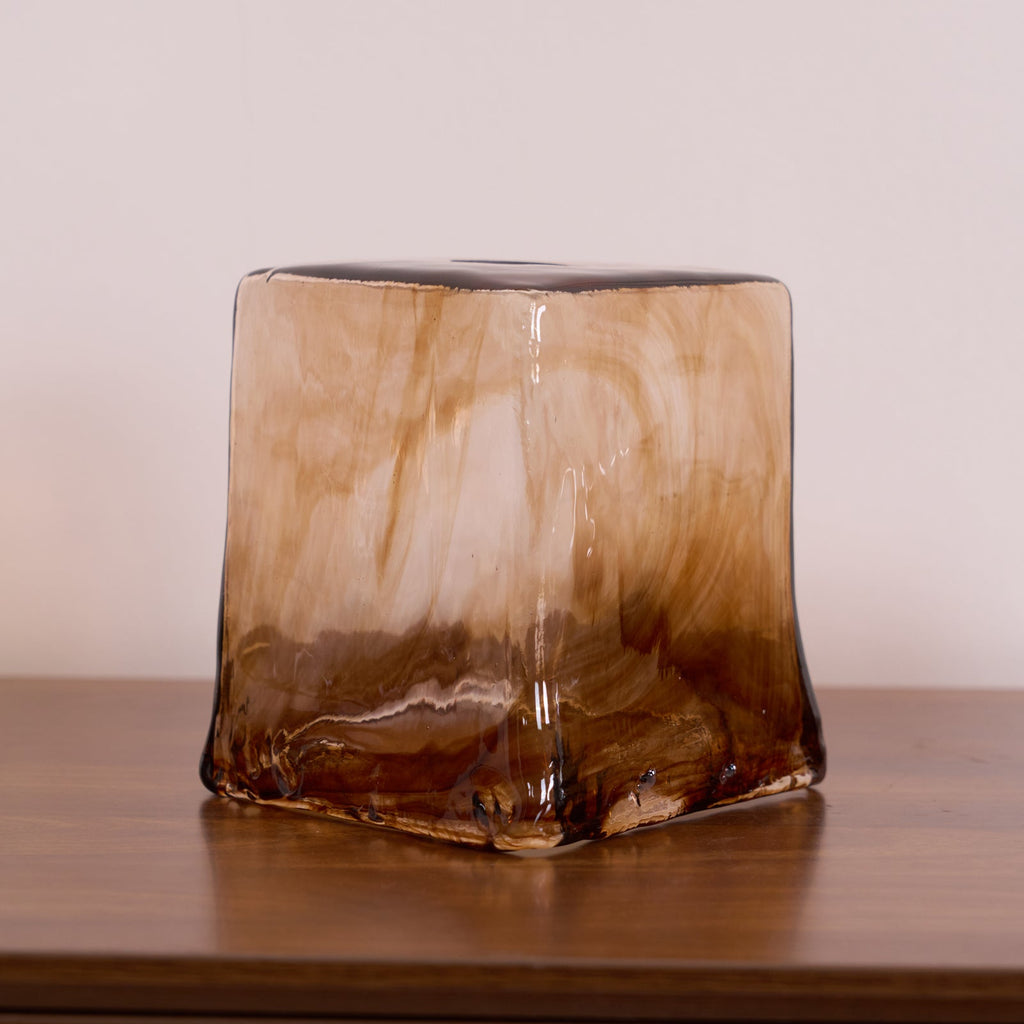 A loose squared Clérachic amber glass shade on a wooden surface, with fused brown glass at the corners and a clear top opening.