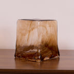 A loose squared Clérachic amber glass shade on a wooden surface, with fused brown glass at the corners and a clear top opening.