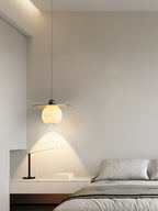 Clérachic Brass and Alabaster Globe Cord Pendant Light on a long drop over a floating bedside shelf and slim desk lamp.