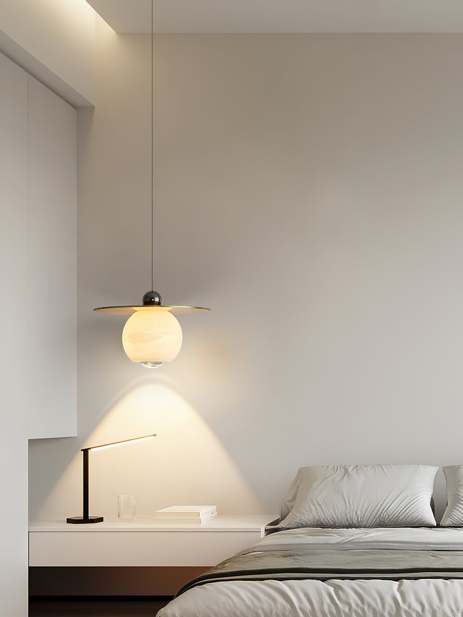 Clérachic Brass and Alabaster Globe Cord Pendant Light on a long drop over a floating bedside shelf and slim desk lamp.