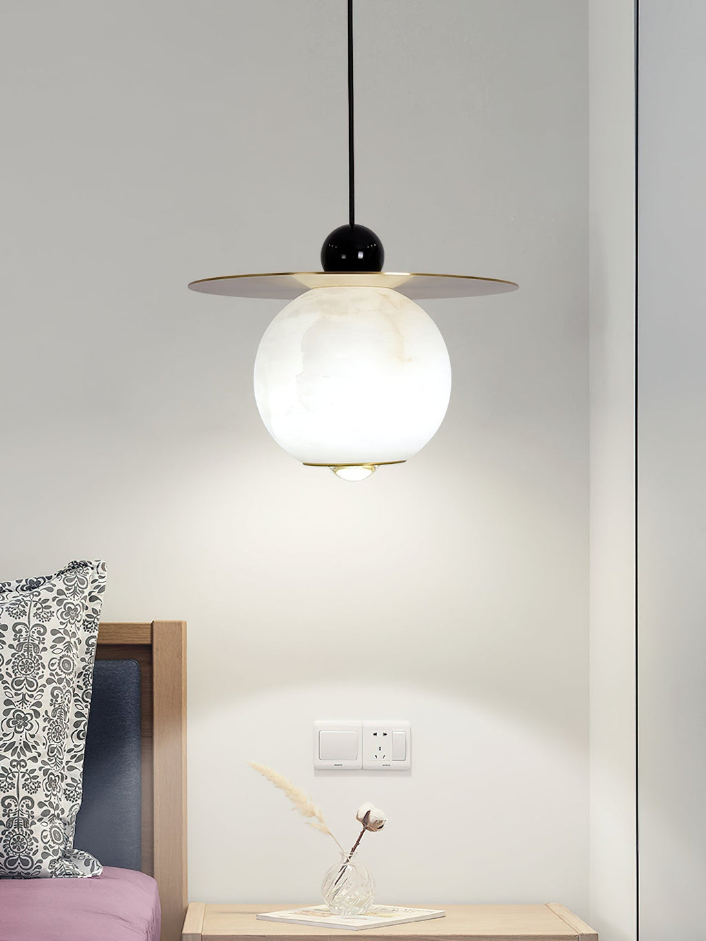 Black gloss finial and brass rim on the Clérachic Brass and Alabaster Globe Cord Pendant Light, lit above a bedside chest.