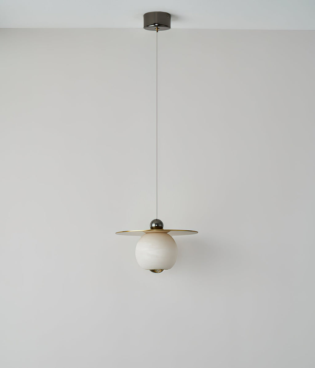 Clérachic Brass and Alabaster Globe Cord Pendant Light at full drop from its round ceiling canopy, switched off.