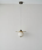 Clérachic Brass and Alabaster Globe Cord Pendant Light at full drop from its round ceiling canopy, switched off.