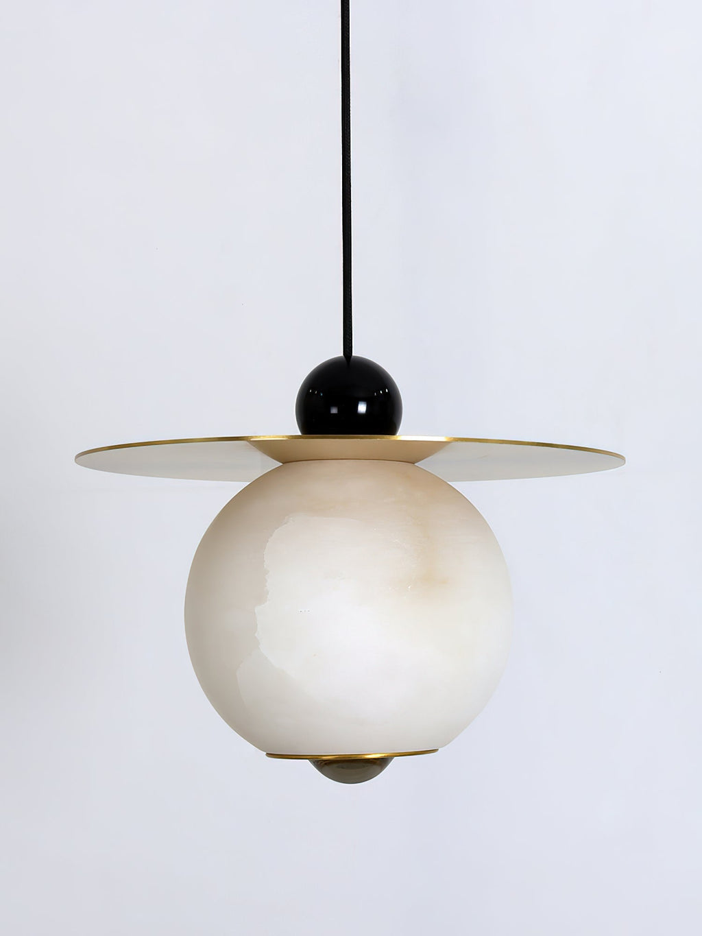 Close study of the Clérachic Brass and Alabaster Globe Cord Pendant Light: black ball, brass disc, veined stone globe.