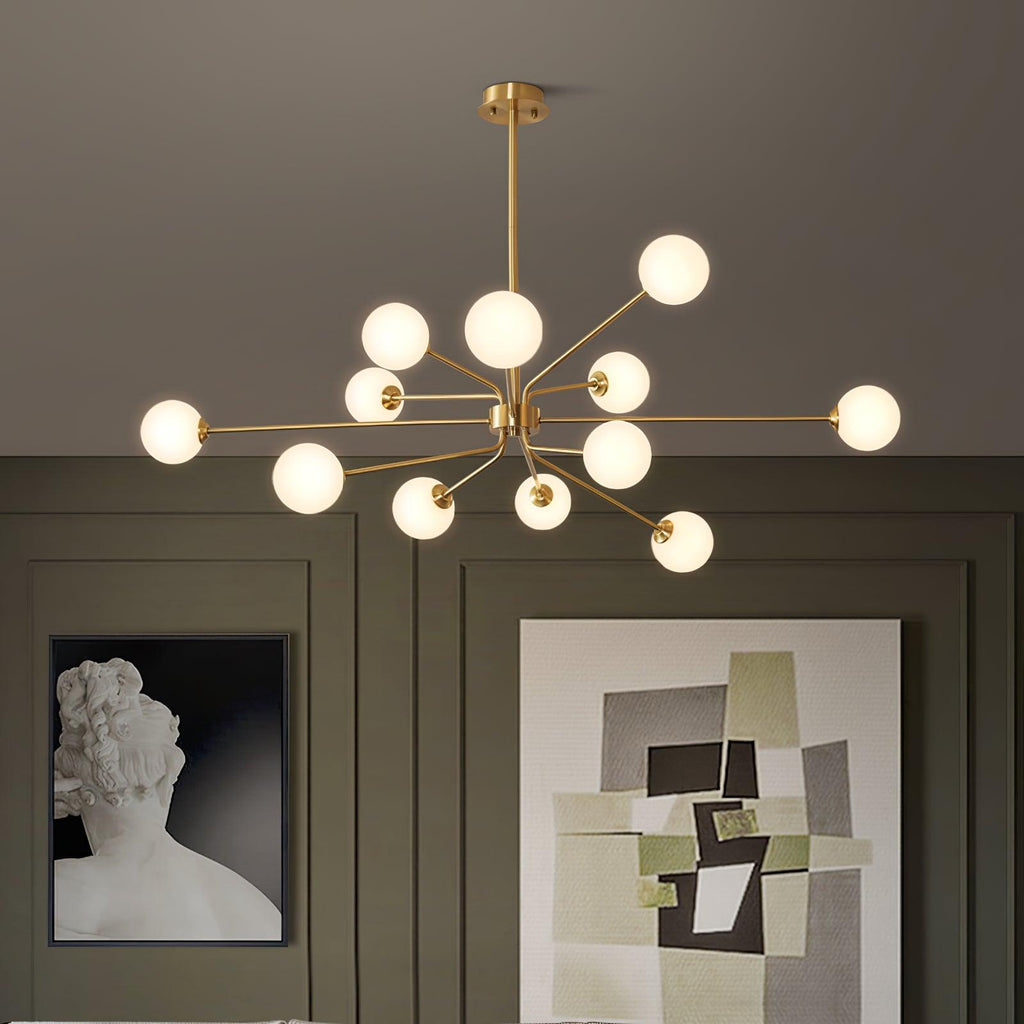 Lit brass Clérachic chandelier with a cluster of white globes, above dark olive panelling, a bust print and an abstract painting.