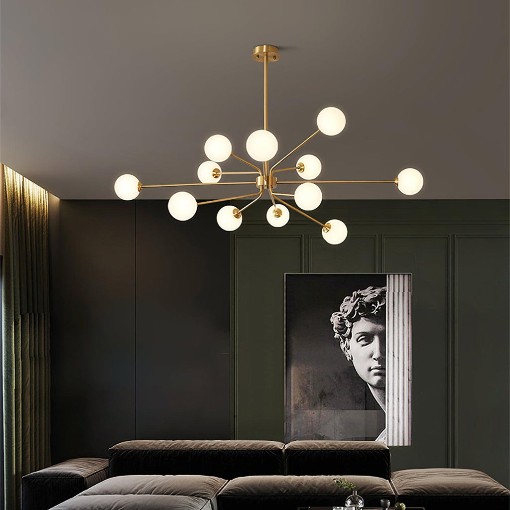 Brass Clérachic chandelier with a dense cluster of white globes above a dark velvet sofa, with a classical bust poster behind.