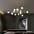 Brass Clérachic chandelier with a dense cluster of white globes above a dark velvet sofa, with a classical bust poster behind.