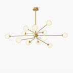Brass Clérachic chandelier with a long central rod and many arms ending in white globes, on a pale backdrop.