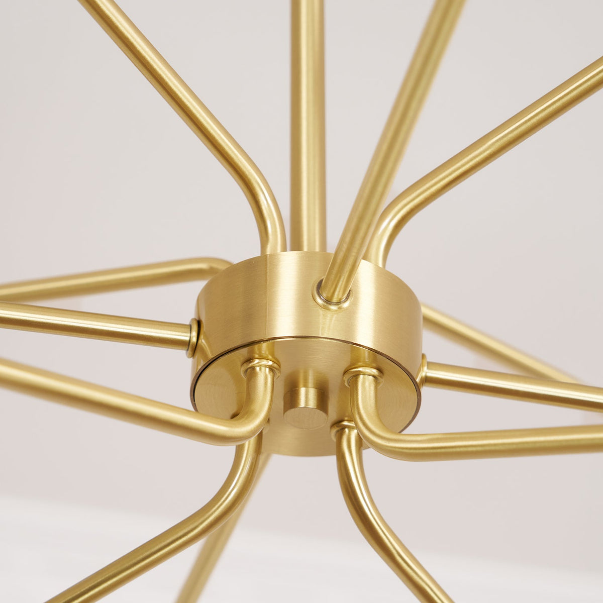 Close view of the brass hub, ceiling-facing arms and central stem of this Clérachic chandelier.