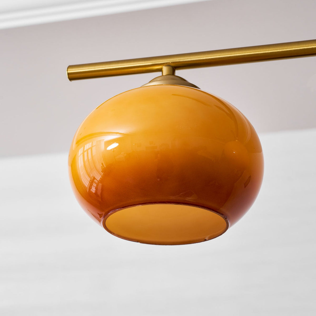 Underside of one Clérachic amber shade, showing its glossy glass shading from gold to brown and the white-lined opening.