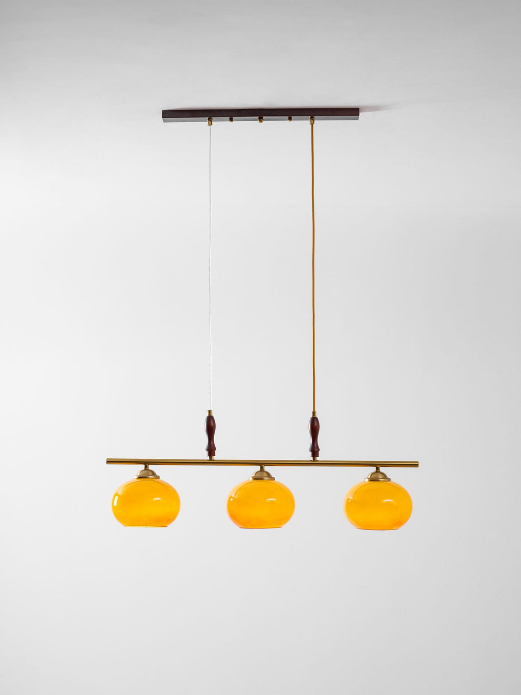 Clérachic three-head bar pendant on a pale backdrop, hung from a dark ceiling plate by one braided cord and one fine wire.
