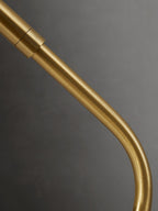 Close view of the curved brass arm and its jointed collar on this Clérachic table lamp.