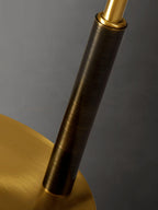Close view of the dark stem meeting the brass arm and the brass base on this Clérachic table lamp.