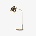 This Clérachic table lamp on a clean white backdrop, with a dark shade, slim brass arm and round brass base.