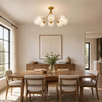 Clérachic ceiling light with rippled glass globes above a long wooden dining table with six cushioned chairs and a framed print.