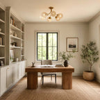 Clérachic glass-globe ceiling light in a study with a chunky wood desk, tall bookshelves and a potted tree in a basket.