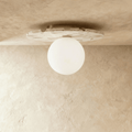 The terrazzo-disc ceiling light glows warm through its round opal glass globe in this Clérachic hero shot.