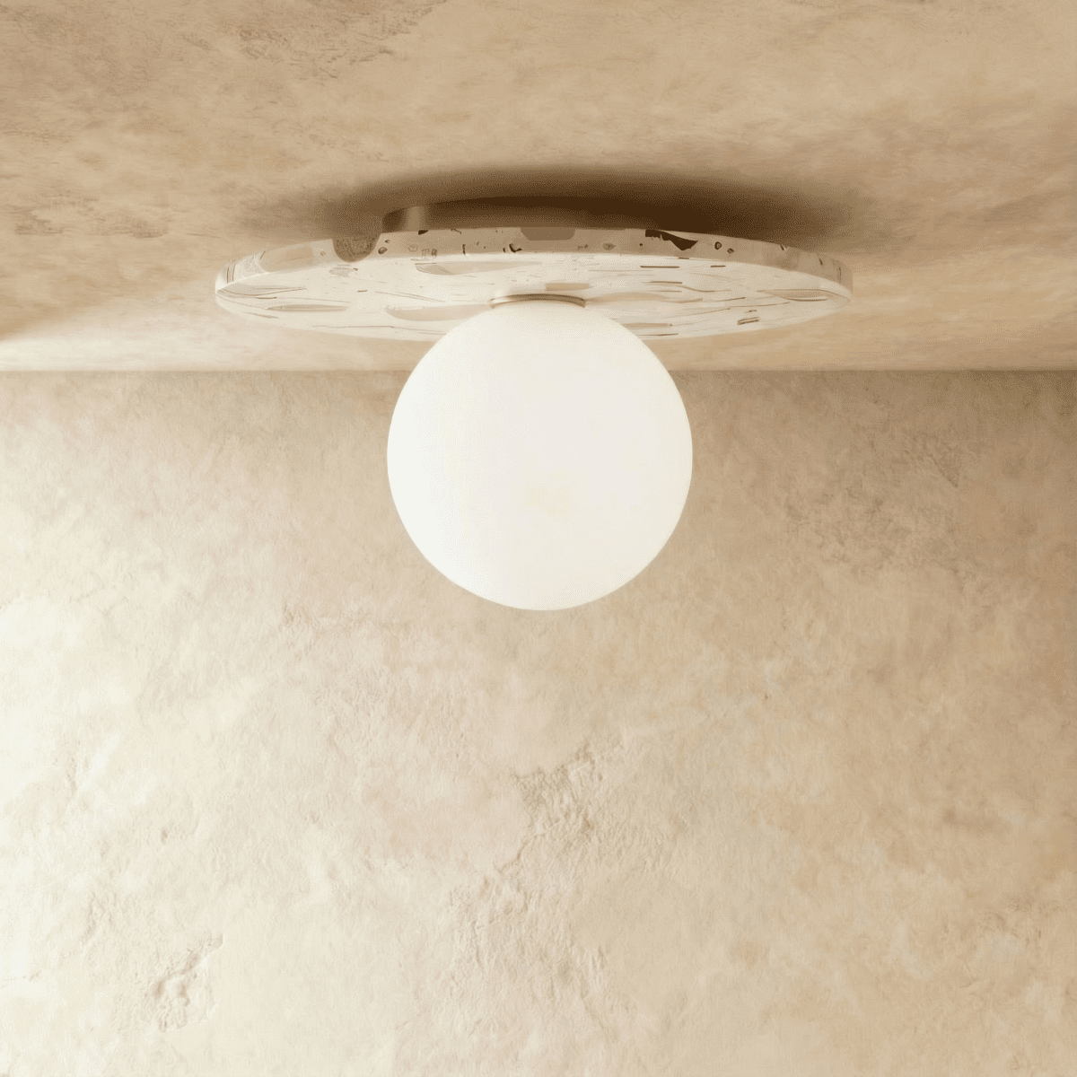 The terrazzo-disc ceiling light glows warm through its round opal glass globe in this Clérachic hero shot.