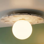A closer crop shows the terrazzo ceiling light's glowing globe against the sage-green bathroom wall, Clérachic detail shot.