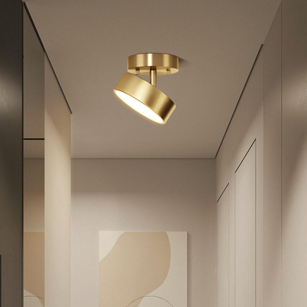 This Clérachic brass ceiling light with its head swung to one side, above a plain hallway with soft beige wall panels.