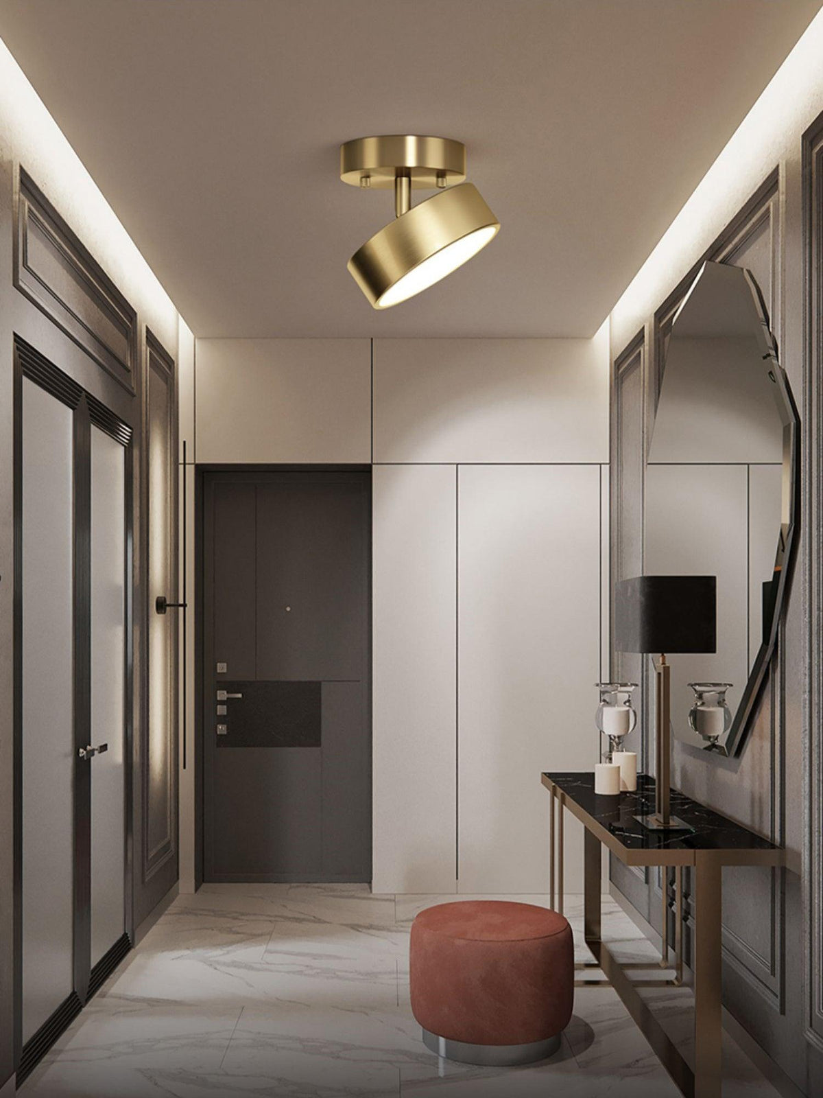 Brass Clérachic ceiling light with its head tilted in an entry hall, above a dark console table and a coral stool.