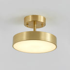 Close view of the Clérachic brass ceiling light, with its brushed metal canopy, thin stem and softly lit round diffuser.