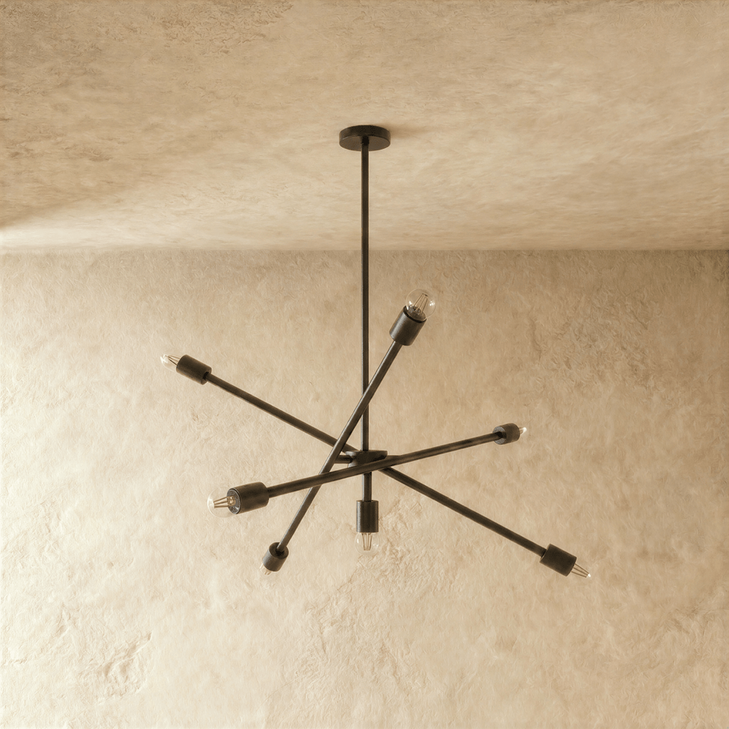 Clérachic sputnik-style chandelier in matte black, shown from a slightly closer studio angle on a plaster wall.
