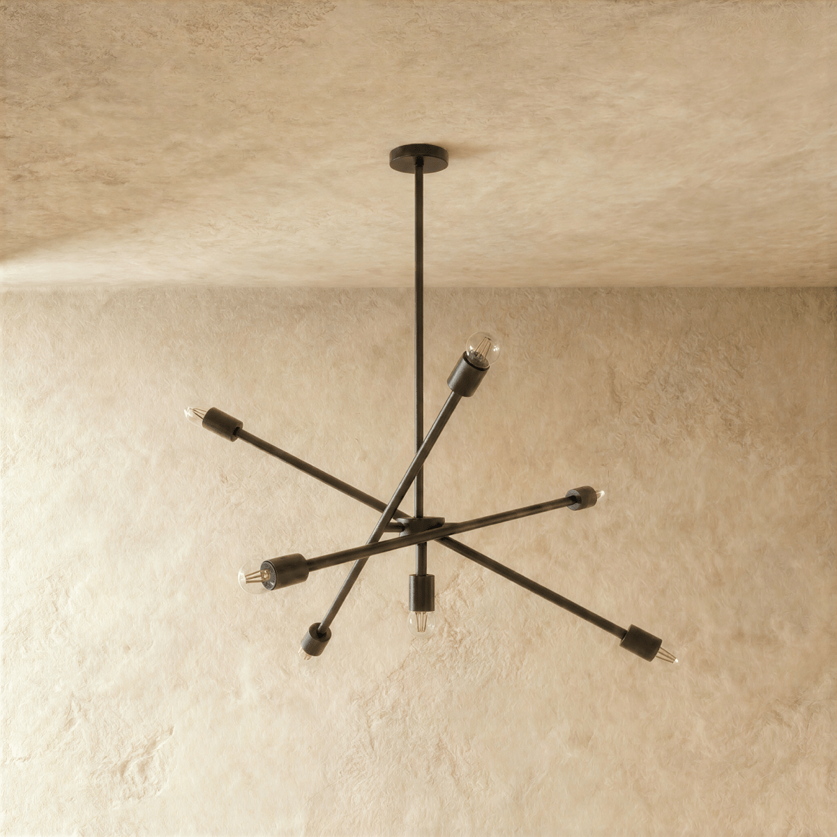 Clérachic sputnik-style chandelier in matte black, shown from a slightly closer studio angle on a plaster wall.