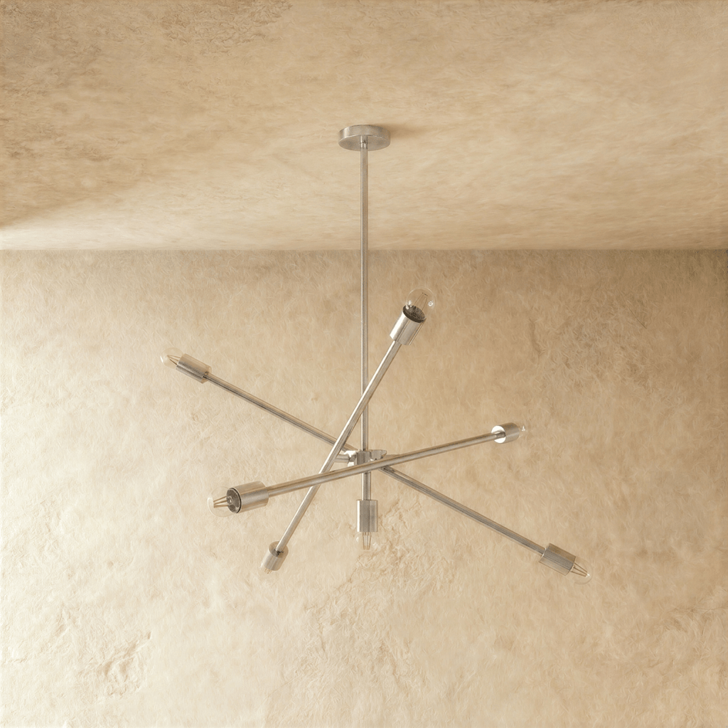 Clérachic sputnik-style chandelier in chrome, shown from a slightly closer studio angle on a plaster wall.