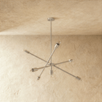 Clérachic sputnik-style chandelier in chrome, shown from a slightly closer studio angle on a plaster wall.