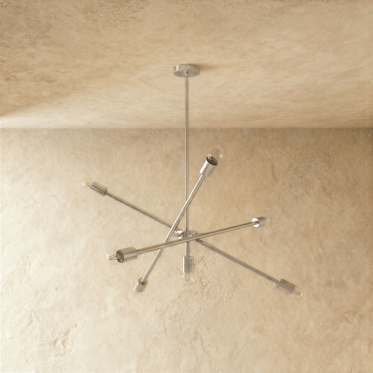 Clérachic sputnik-style chandelier in chrome, shown from a slightly closer studio angle on a plaster wall.