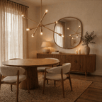 Clérachic brass sputnik chandelier lit above a round dining table, reflected in a mirror beside a wooden sideboard.