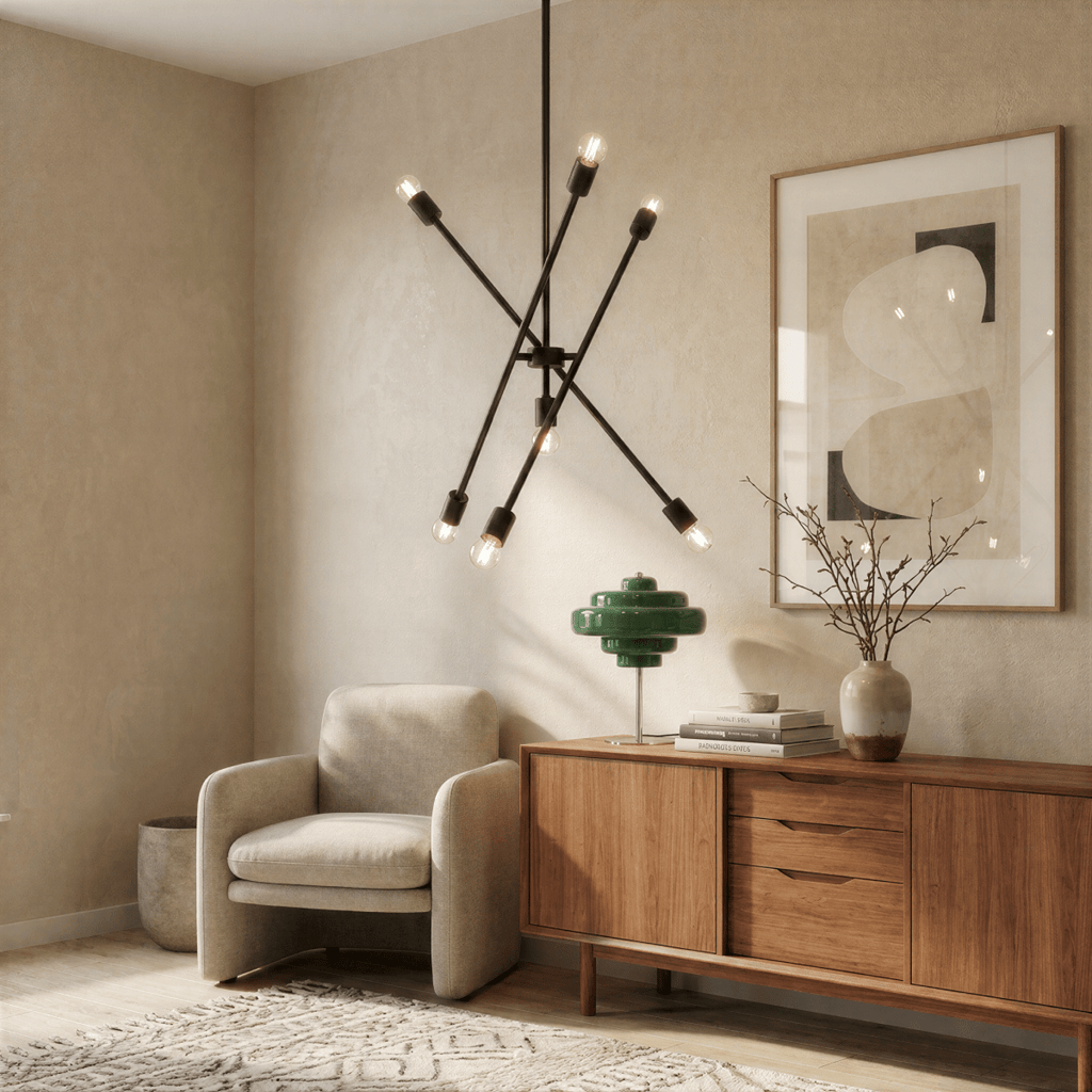 Clérachic matte black sputnik chandelier lit beside an armchair, a green table lamp and a wooden sideboard.