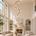 Clérachic chandelier lit in a tall room with arched windows, above a white fireplace flanked by built-in shelves.