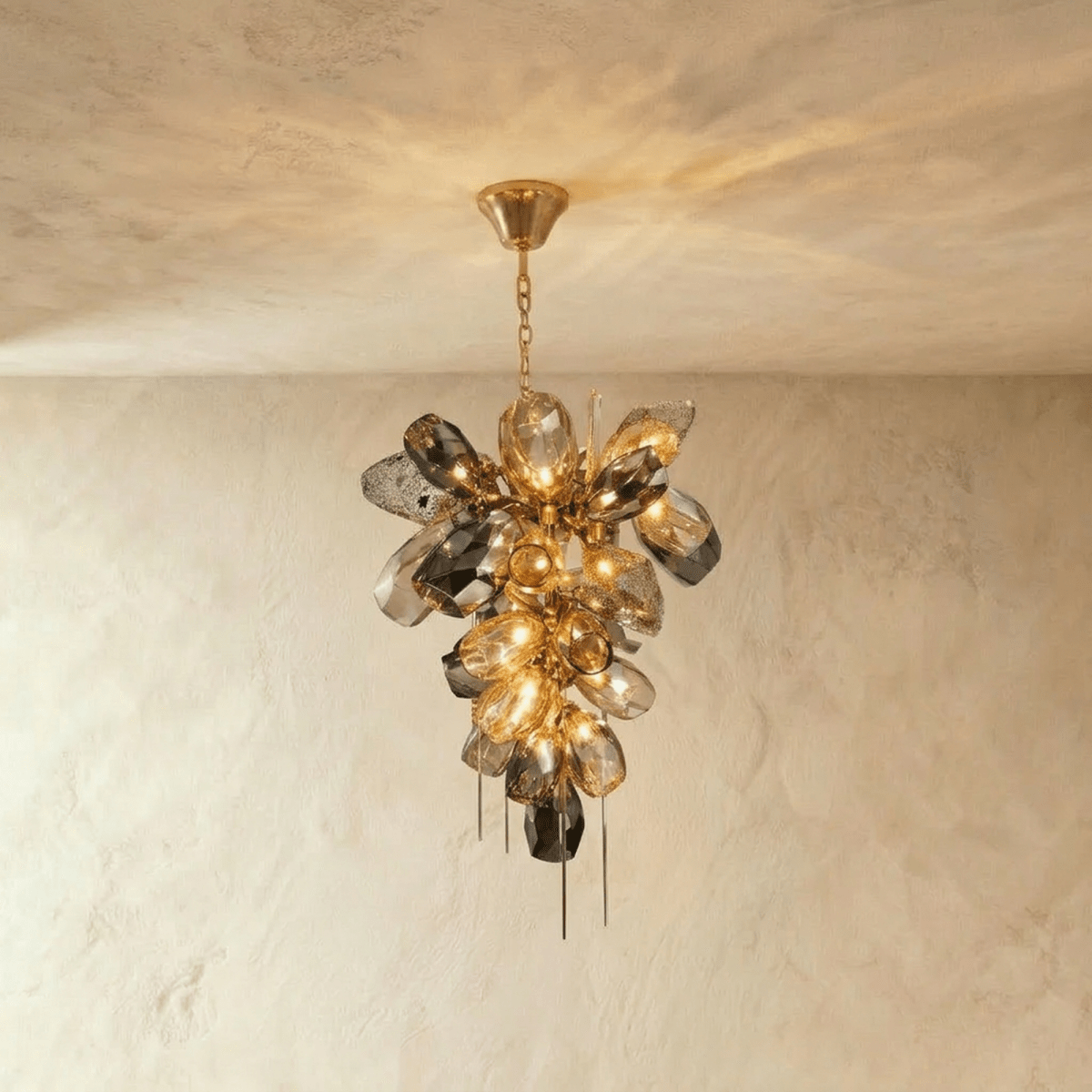 Clérachic chandelier with a cluster of faceted cognac and smoked glass pieces on a brass-finished frame, hung from a short chain.