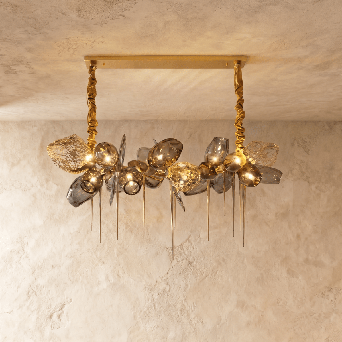 Clérachic linear chandelier with smoked glass shades and brass mesh pieces, hung from two gold fabric-wrapped chains on a bar canopy.