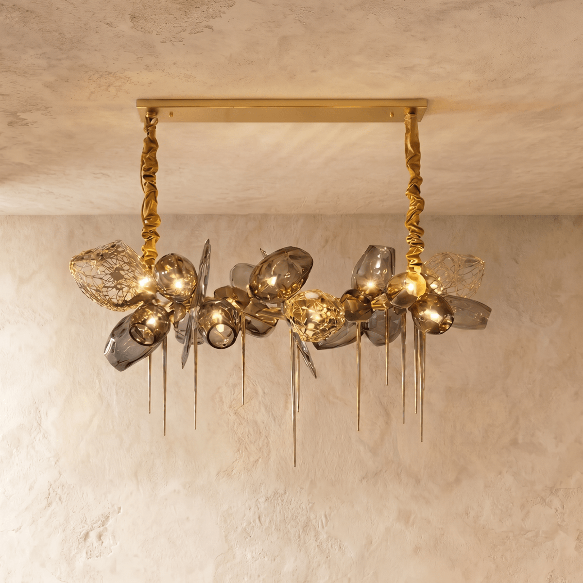 Clérachic rectangular-canopy chandelier with grey glass globes, openwork brass shades and pointed brass spikes, lit warm.