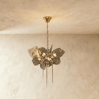 Clérachic compact chandelier with ribbed grey glass petals, one brass lattice shade and three hanging spikes on a brass chain.