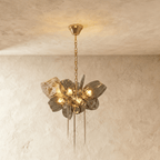 Clérachic brass-chain chandelier with ribbed smoked glass petals and a lattice shade, glowing warm beneath a round brass canopy.