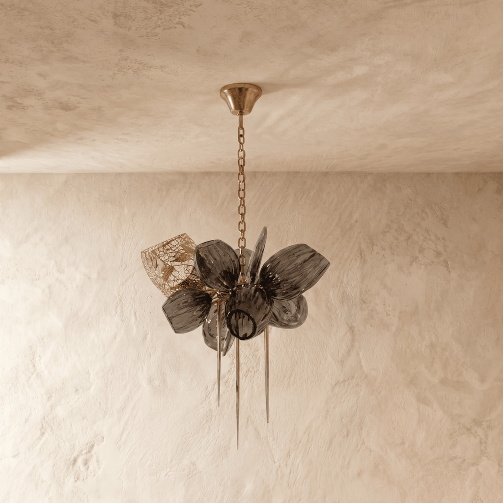 Clérachic chandelier with ribbed smoked glass petals, switched off, hanging from a fine brass chain against a limewash wall.